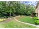 Beautiful backyard featuring a stone wall, lush lawn, and mature trees at 4896 Locklear Way, Marietta, GA 30066