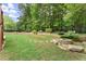 Expansive backyard featuring a stone fire pit, mature trees, and lush green grass at 4896 Locklear Way, Marietta, GA 30066