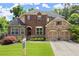 Charming two-story brick home featuring a manicured lawn, stone accents, and a two-car garage at 4896 Locklear Way, Marietta, GA 30066