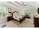 Main bedroom with a ceiling fan, tray ceilings, shuttered windows, and hardwood furniture at 4896 Locklear Way, Marietta, GA 30066