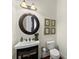 Elegant powder room featuring a sleek corner sink, round mirror, and tasteful botanical wall art at 4896 Locklear Way, Marietta, GA 30066