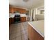 Well-lit kitchen featuring tile flooring, wood cabinetry, and stainless steel appliances at 213 Peartree Ln, Riverdale, GA 30274