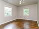 Bright bedroom with hardwood floors and two windows offering a view of lush greenery at 2582 Springdale Sw Rd, Atlanta, GA 30315