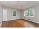 Bright bedroom with hardwood floors and two windows offering a view of lush greenery at 2582 Springdale Sw Rd, Atlanta, GA 30315