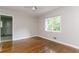 Bedroom featuring hardwood floors, a ceiling fan, and a large window overlooking lush greenery at 2582 Springdale Sw Rd, Atlanta, GA 30315