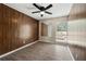 Cozy bedroom with wood paneled walls, hardwood floors, ceiling fan and natural light at 3184 Nectarine Cir, Decatur, GA 30034