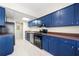 A well-lit kitchen featuring stainless steel appliances, vibrant blue cabinets, and sleek countertops at 3184 Nectarine Cir, Decatur, GA 30034