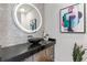 Stylish powder room featuring modern fixtures, granite counters, and an elegant round mirror at 45 Ivan Allen Jr Nw Blvd # 2505, Atlanta, GA 30308