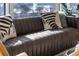 Close up of modern leather sofa with stylish pillows, bathed in natural light from expansive windows at 45 Ivan Allen Jr Nw Blvd # 2505, Atlanta, GA 30308