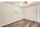 Light-filled bedroom featuring hardwood floors, neutral walls, and a modern light fixture at 62 Sunny Ln, Villa Rica, GA 30180