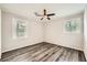This bedroom offers two windows and attractive wood-look flooring and a ceiling fan at 62 Sunny Ln, Villa Rica, GA 30180