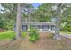 Charming single-story home featuring a gray brick exterior, a small front porch, and mature shade trees at 62 Sunny Ln, Villa Rica, GA 30180