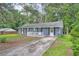 View of a well-maintained single-story home with a gray brick exterior and a concrete driveway leading up to it at 62 Sunny Ln, Villa Rica, GA 30180