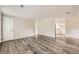 Spacious living room featuring gray wood-look floors, light gray walls, and views into the adjacent kitchen at 62 Sunny Ln, Villa Rica, GA 30180