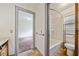 Bathroom featuring combination tub and shower, shelving, toilet, and view of bedroom at 1237 Hunters Dr, Stone Mountain, GA 30083