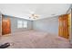 Bedroom featuring two entry doorways, two windows, neutral paint, and plush carpeting at 1237 Hunters Dr, Stone Mountain, GA 30083