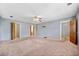Bedroom featuring a ceiling fan, neutral paint, ensuite bath, and plush carpeting at 1237 Hunters Dr, Stone Mountain, GA 30083