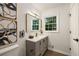 Bathroom featuring a vanity with a gray cabinet, gold fixtures, and modern wall art at 3536 Redwine Ct, Atlanta, GA 30344