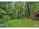 Lush backyard with mature trees, grass, and access stairs to the back of the house at 1215 Vista Leaf Dr, Decatur, GA 30033