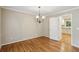 Bright dining room featuring hardwood floors, classic chandelier, and open doorway to the adjacent kitchen at 1215 Vista Leaf Dr, Decatur, GA 30033