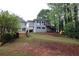 The backyard has a small deck, trees, and a swing set for fun activities at 168 Harmony Grove Rd, Lilburn, GA 30047