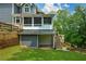 Backyard featuring lower level garage access, stairs to screened in porch, and well maintained grass at 2637 Morningside Nw Trl, Kennesaw, GA 30144