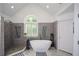 A gorgeous bathroom features a soaking tub, shower, and arched window at 2637 Morningside Nw Trl, Kennesaw, GA 30144