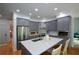 Modern kitchen boasts stainless steel appliances, gray cabinets, and a center island with a white countertop at 2637 Morningside Nw Trl, Kennesaw, GA 30144