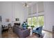 Bright living room with high ceilings, large windows, and cozy seating around a fireplace at 2637 Morningside Nw Trl, Kennesaw, GA 30144