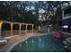 Inviting outdoor pool area with a wooden deck, pergola, and charming string lights, perfect for evening relaxation at 2637 Morningside Nw Trl, Kennesaw, GA 30144