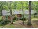 Backyard view of a brick house with mature trees and an AC unit at 286 Hilton Way Way, Canton, GA 30114