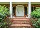 Close-up of the brick front porch with white columns and a white front door, decorated with bushes at 286 Hilton Way Way, Canton, GA 30114