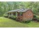 Brick home side view with mature landscaping, showcasing the length of the covered front porch at 286 Hilton Way Way, Canton, GA 30114