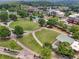 An aerial view shows a town center with a large green, an amphitheater, walking paths, and mixed-use buildings at 3743 Lake Edge Dr, Suwanee, GA 30024
