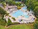 Aerial view of the community pool with slides, lounge areas, and lush landscaping at 3743 Lake Edge Dr, Suwanee, GA 30024