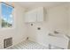 Functional laundry room with storage cabinets, a utility sink, and a large window at 3743 Lake Edge Dr, Suwanee, GA 30024