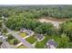 Aerial view of neighborhood homes backing up to lush tree line and small lake at 605 Pebble Blvd, Covington, GA 30016