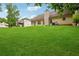 View of the spacious yard with covered porch, mature trees and a home with neutral siding at 605 Pebble Blvd, Covington, GA 30016