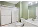 Bathroom features a shower with sliding glass doors, a toilet, and a vanity sink, designed for functionality and style at 605 Pebble Blvd, Covington, GA 30016