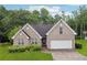 Charming single-Gathering home with brick facade, manicured lawn, and an attached two-car garage at 605 Pebble Blvd, Covington, GA 30016