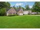 Beautiful brick house featuring an attached garage, a green lawn, and mature trees at 605 Pebble Blvd, Covington, GA 30016