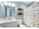 Bright bathroom featuring blue walls, shelves, and a shower-tub combo at 3012 Dempsey Pl, Lawrenceville, GA 30044
