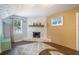 Cozy living room featuring a stone fireplace, wood floors, and natural light at 3012 Dempsey Pl, Lawrenceville, GA 30044