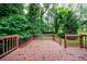 Wooden back deck with brown railings surrounded by lush green trees at 3135 Washington Rd, Atlanta, GA 30344