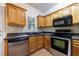 Kitchen featuring stainless steel appliances, sleek black countertops, and wood cabinetry at 3135 Washington Rd, Atlanta, GA 30344