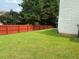 Red wooden fence surrounds the spacious backyard of the home at 4424 High Gate Nw Dr, Acworth, GA 30101