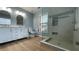 Bathroom featuring wood floors, modern glass shower, dual sink vanity, and bright natural lighting at 4424 High Gate Nw Dr, Acworth, GA 30101