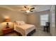 Cozy bedroom with a floral bedspread, wood side table with lamp, ceiling fan, and neutral walls at 4424 High Gate Nw Dr, Acworth, GA 30101