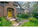 Inviting yellow front door of a brick home, enhanced by a cozy seating area and vibrant landscaping at 451 S Columbia Dr, Decatur, GA 30030