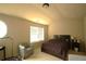 Bright bedroom with neutral carpet, a window letting in natural light, a bed, and sitting area at 560 Tuscany Walk Ln, Lawrenceville, GA 30043